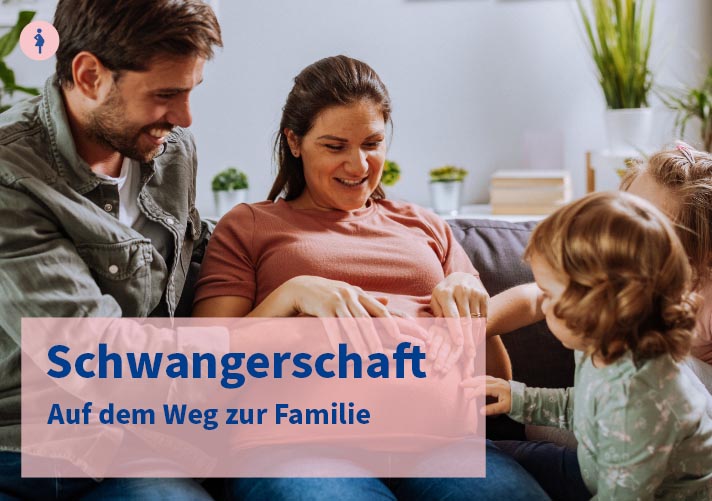 Eine junge Familie sitzt gemeinsam auf der Couch